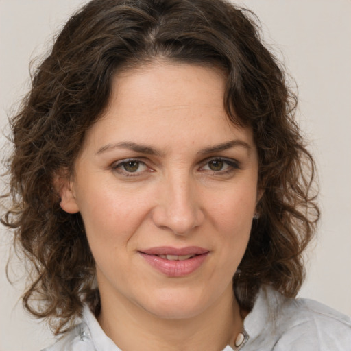 Joyful white young-adult female with medium  brown hair and green eyes