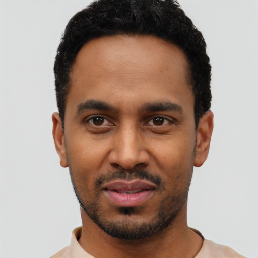Joyful black young-adult male with short  black hair and brown eyes