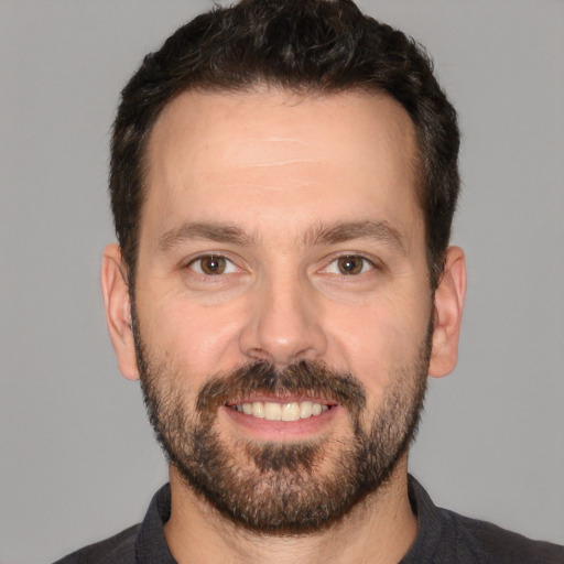 Joyful white adult male with short  brown hair and brown eyes