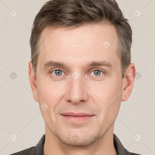 Joyful white young-adult male with short  brown hair and grey eyes