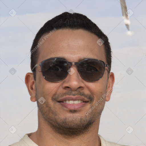 Joyful latino young-adult male with short  black hair and brown eyes