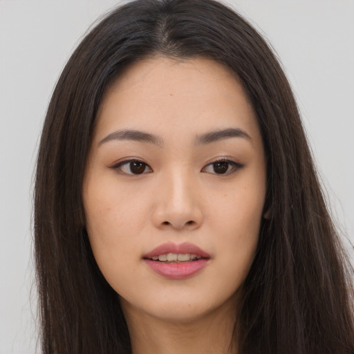 Joyful asian young-adult female with long  brown hair and brown eyes