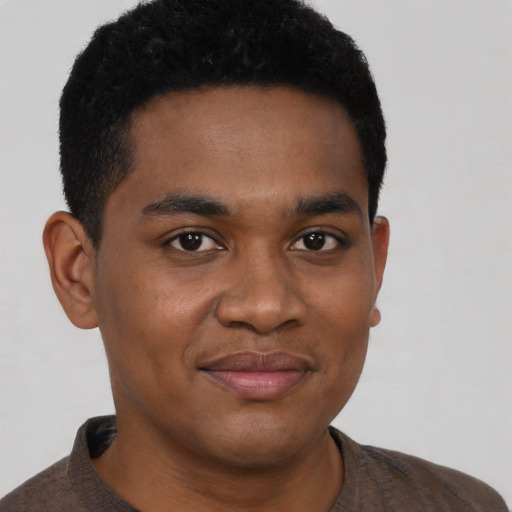 Joyful black young-adult male with short  black hair and brown eyes