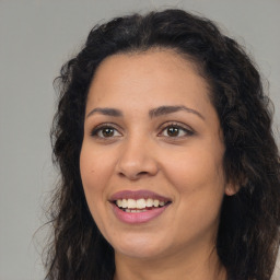 Joyful latino adult female with long  brown hair and brown eyes