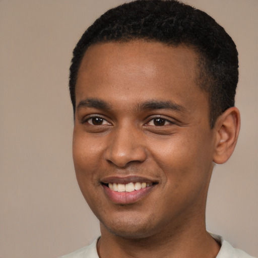 Joyful black young-adult male with short  brown hair and brown eyes