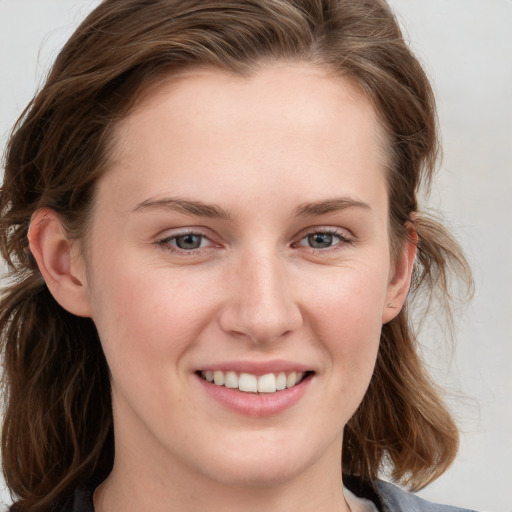 Joyful white young-adult female with long  brown hair and blue eyes