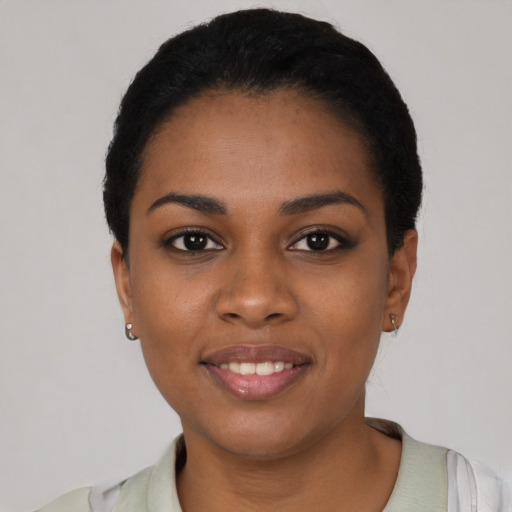Joyful black young-adult female with short  black hair and brown eyes