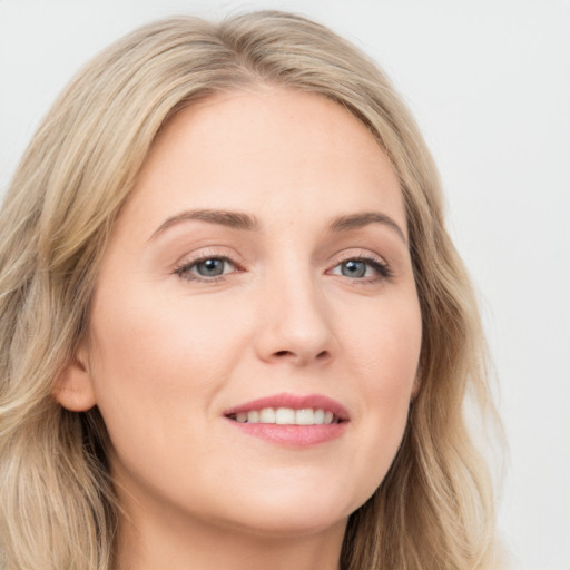 Joyful white young-adult female with long  brown hair and blue eyes