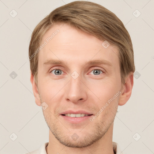 Joyful white young-adult male with short  brown hair and grey eyes