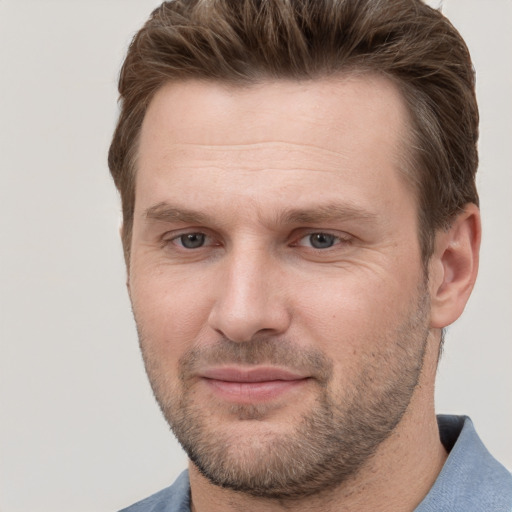 Joyful white adult male with short  brown hair and grey eyes