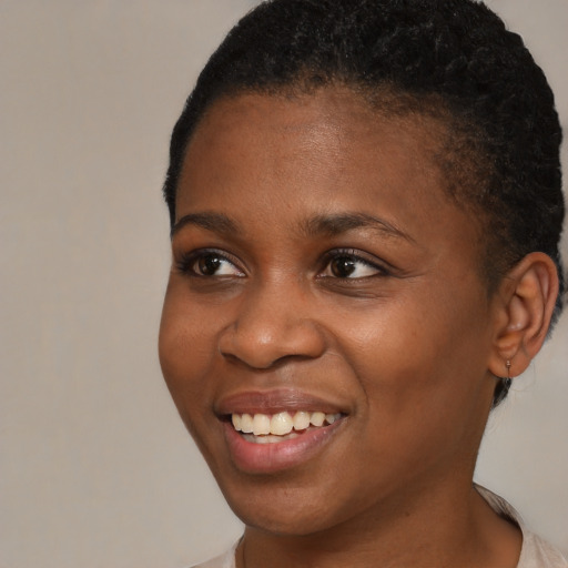 Joyful black young-adult female with short  brown hair and brown eyes
