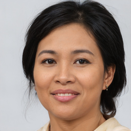 Joyful asian adult female with medium  brown hair and brown eyes