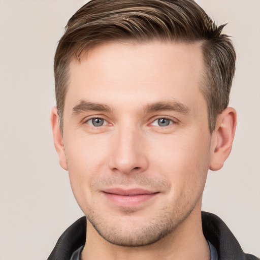 Joyful white young-adult male with short  brown hair and grey eyes