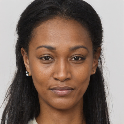 Joyful black young-adult female with long  brown hair and brown eyes