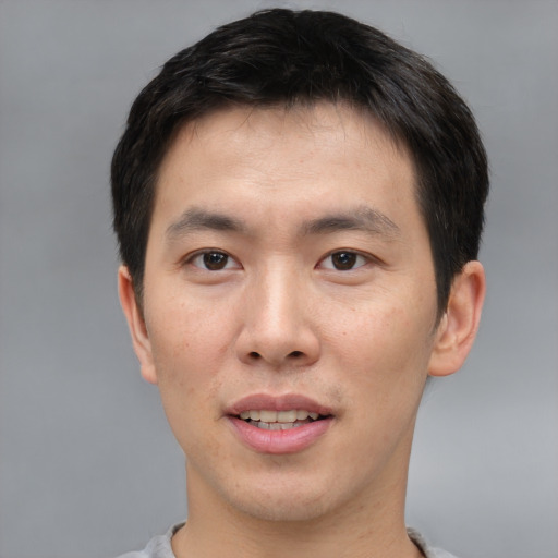 Joyful asian young-adult male with short  brown hair and brown eyes