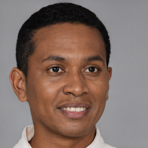 Joyful black young-adult male with short  black hair and brown eyes