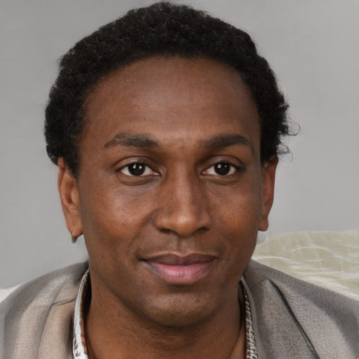 Joyful black adult male with short  brown hair and brown eyes