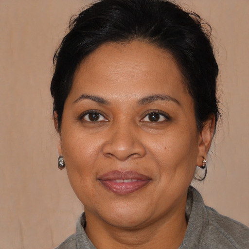 Joyful latino adult female with medium  brown hair and brown eyes