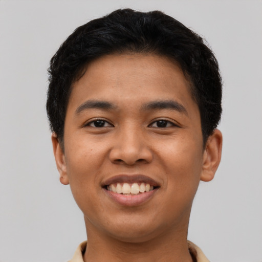 Joyful latino young-adult male with short  brown hair and brown eyes