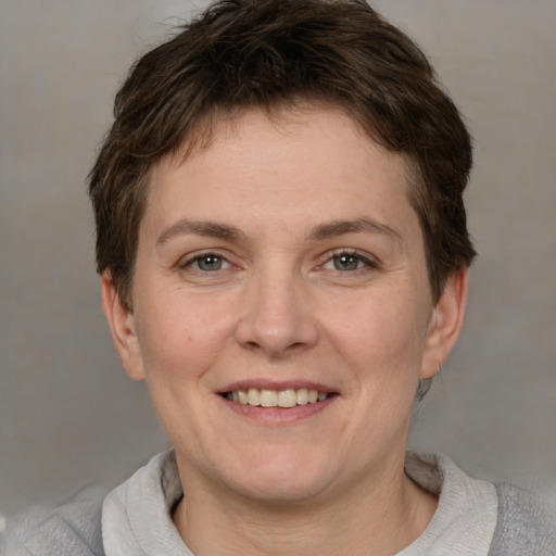 Joyful white adult female with short  brown hair and grey eyes