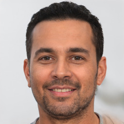 Joyful white young-adult male with short  black hair and brown eyes