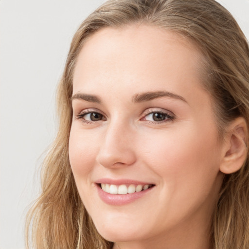 Joyful white young-adult female with long  brown hair and grey eyes