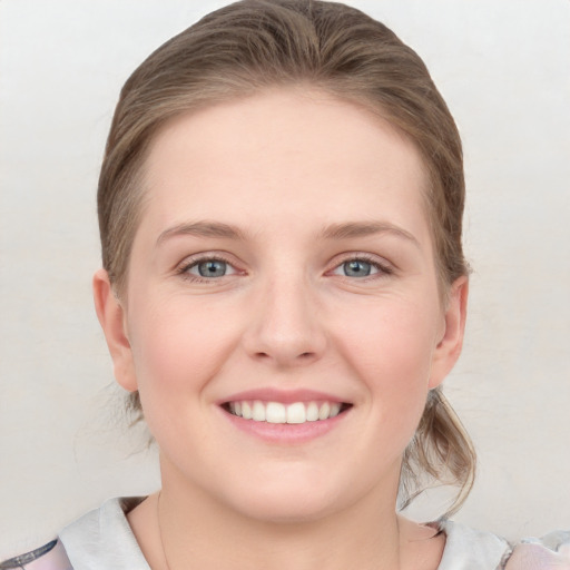 Joyful white young-adult female with medium  brown hair and blue eyes