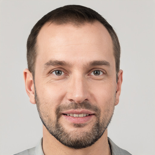 Joyful white young-adult male with short  brown hair and grey eyes