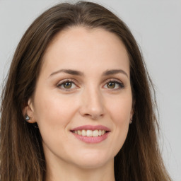 Joyful white young-adult female with long  brown hair and green eyes