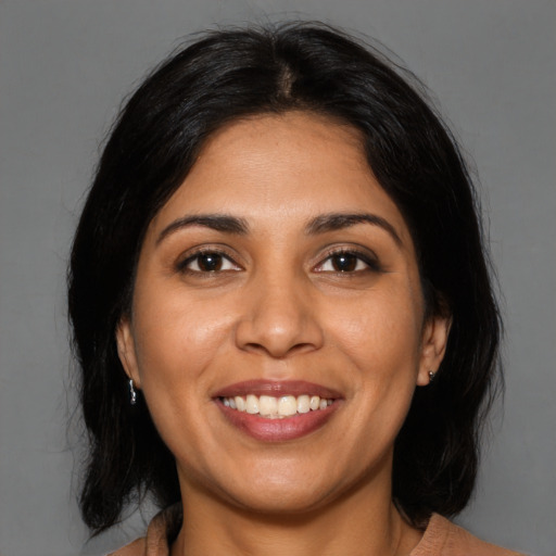 Joyful latino young-adult female with medium  black hair and brown eyes