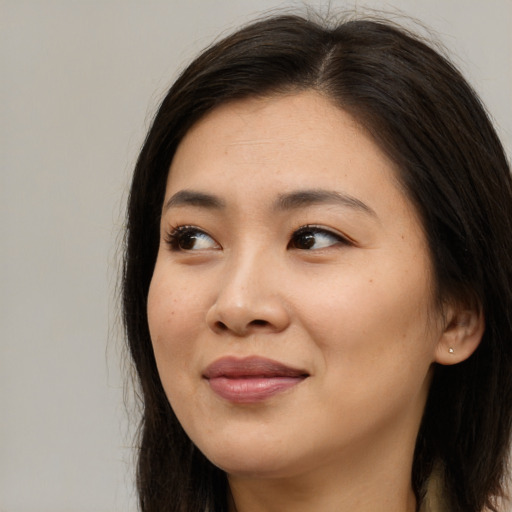 Joyful asian young-adult female with long  brown hair and brown eyes