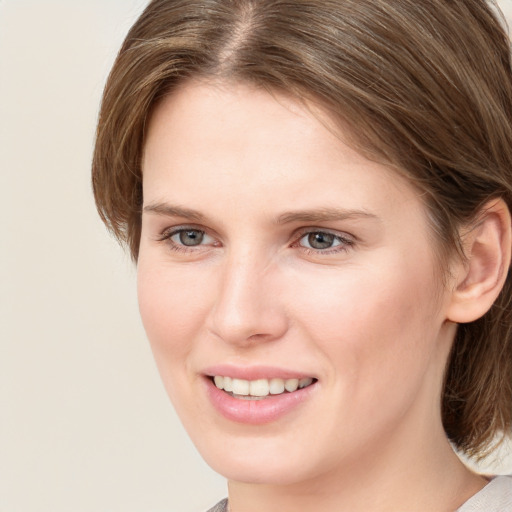 Joyful white young-adult female with medium  brown hair and blue eyes