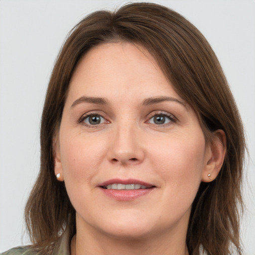 Joyful white young-adult female with long  brown hair and grey eyes