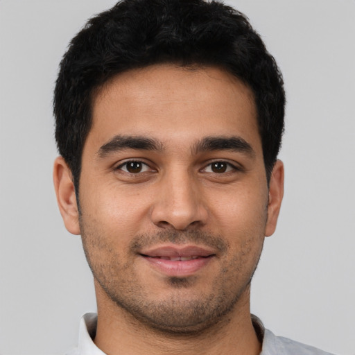 Joyful latino young-adult male with short  black hair and brown eyes