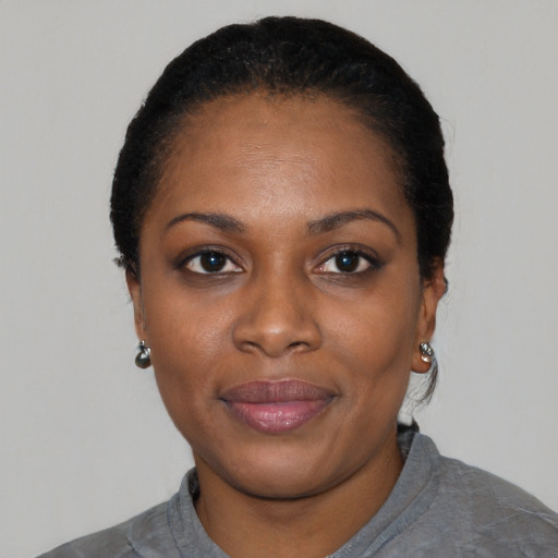 Joyful black young-adult female with short  black hair and brown eyes