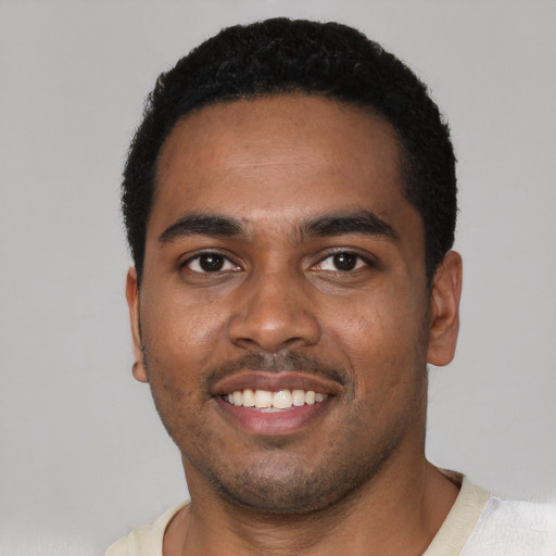 Joyful black young-adult male with short  black hair and brown eyes