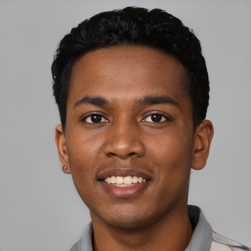 Joyful black young-adult male with short  black hair and brown eyes