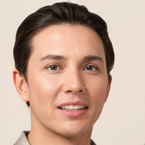 Joyful white young-adult male with short  brown hair and grey eyes