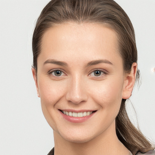 Joyful white young-adult female with long  brown hair and grey eyes