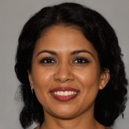 Joyful black adult female with medium  brown hair and brown eyes