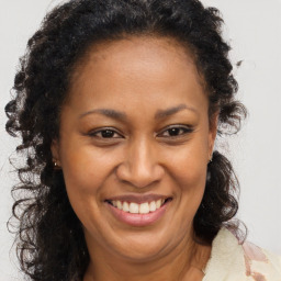 Joyful black adult female with long  brown hair and brown eyes