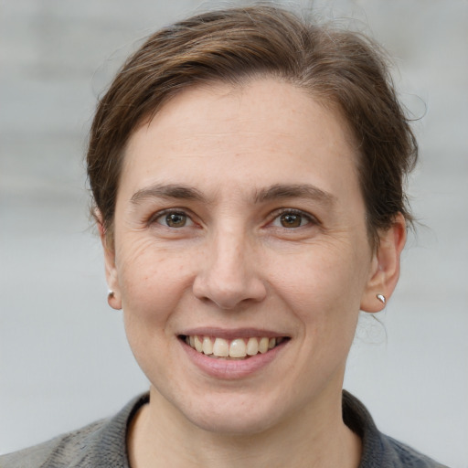 Joyful white young-adult female with short  brown hair and grey eyes