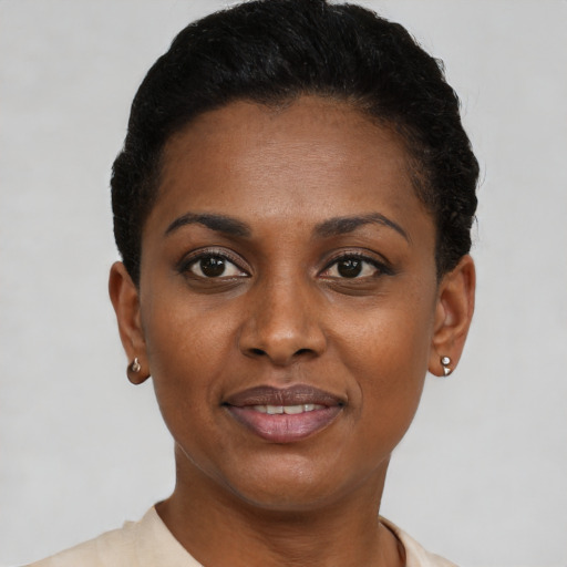 Joyful black young-adult female with short  black hair and brown eyes