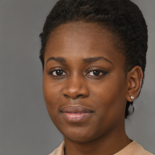Joyful black young-adult female with short  black hair and brown eyes