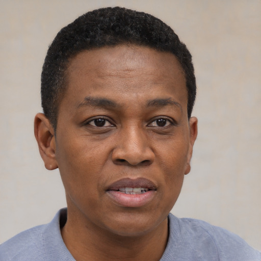 Joyful black adult male with short  brown hair and brown eyes