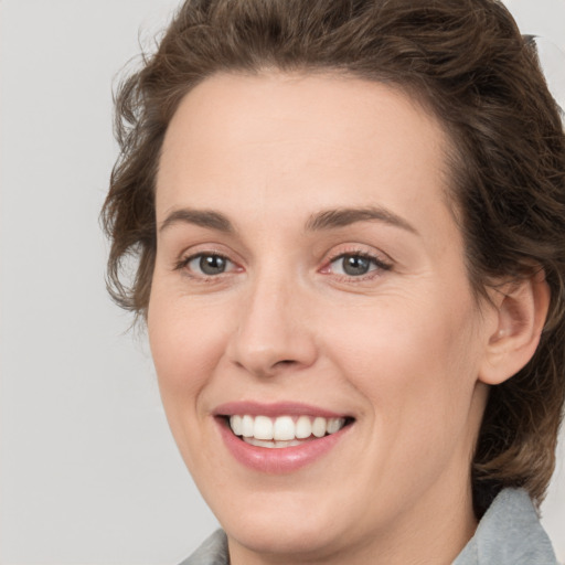 Joyful white young-adult female with medium  brown hair and green eyes