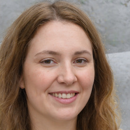 Joyful white adult female with long  brown hair and green eyes