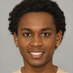 Joyful black young-adult male with short  brown hair and brown eyes