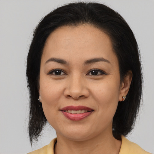 Joyful asian adult female with medium  brown hair and brown eyes