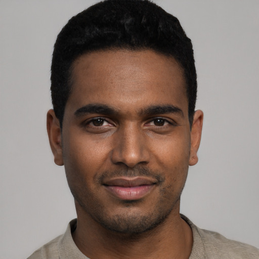 Joyful black young-adult male with short  black hair and brown eyes